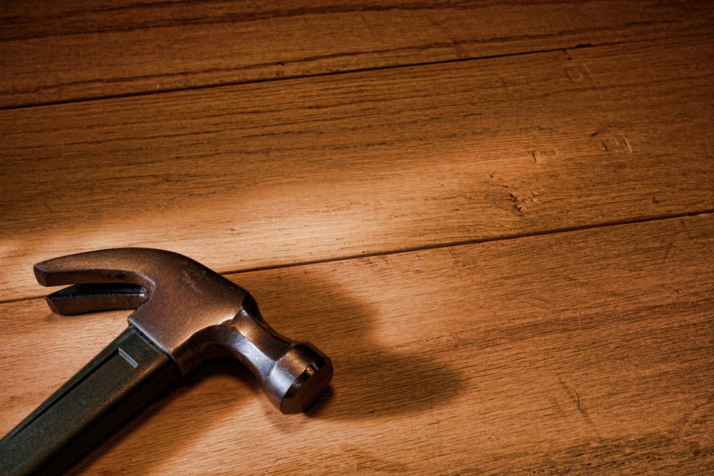Claw hammer resting on a wood background