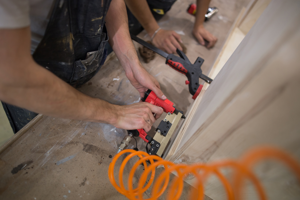 carpenters using pneumatic nail gun