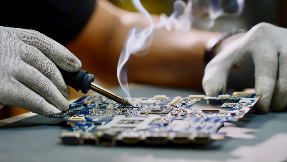 Technician soldering component on circuit board