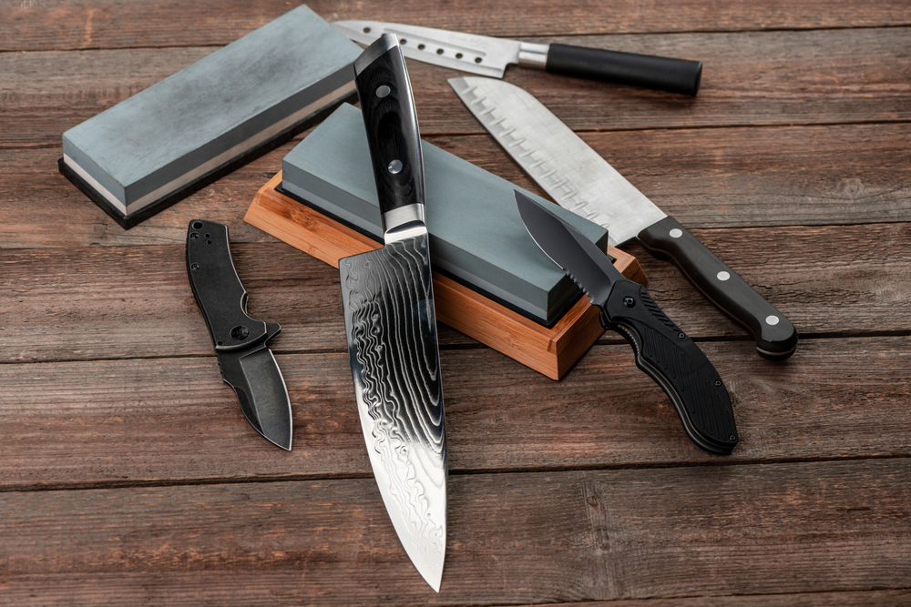 assorted knives sitting on top of whetstone