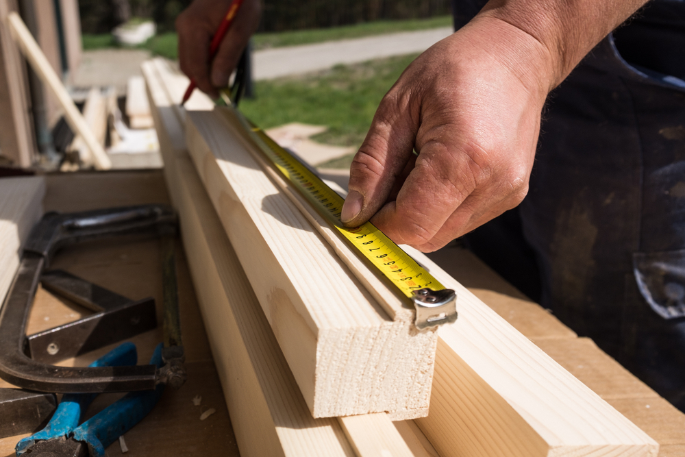 A man measuring lumber