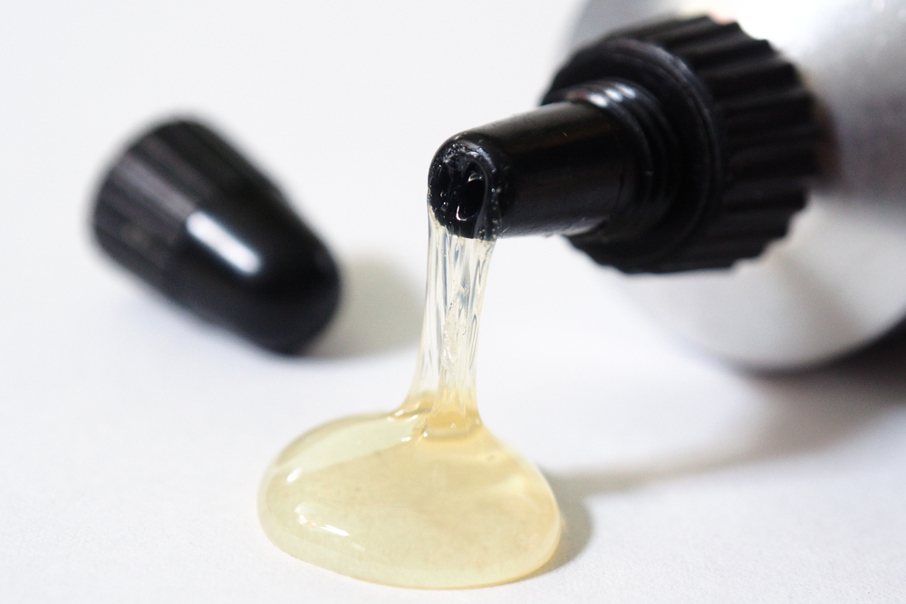 a bottle of adhesive spilling on to a white table