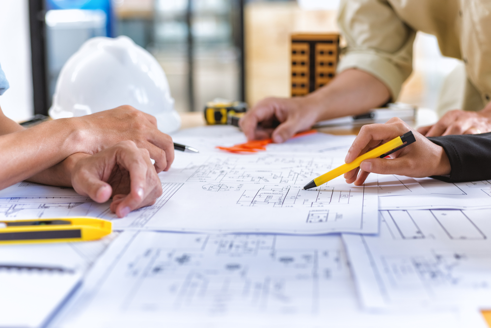 close-up of three architects looking at blueprints