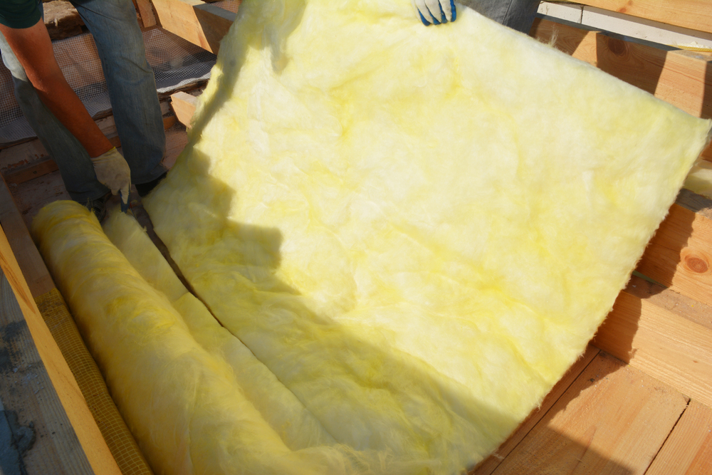 Worker cutting blanket batt insulation