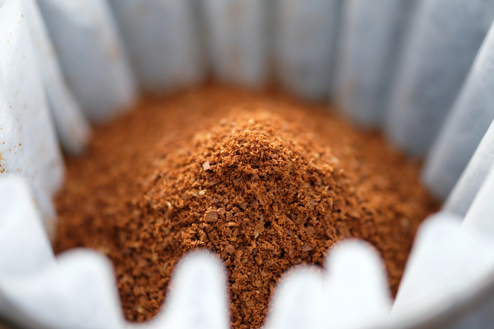 close up pile of dry coffee grinds in white filter