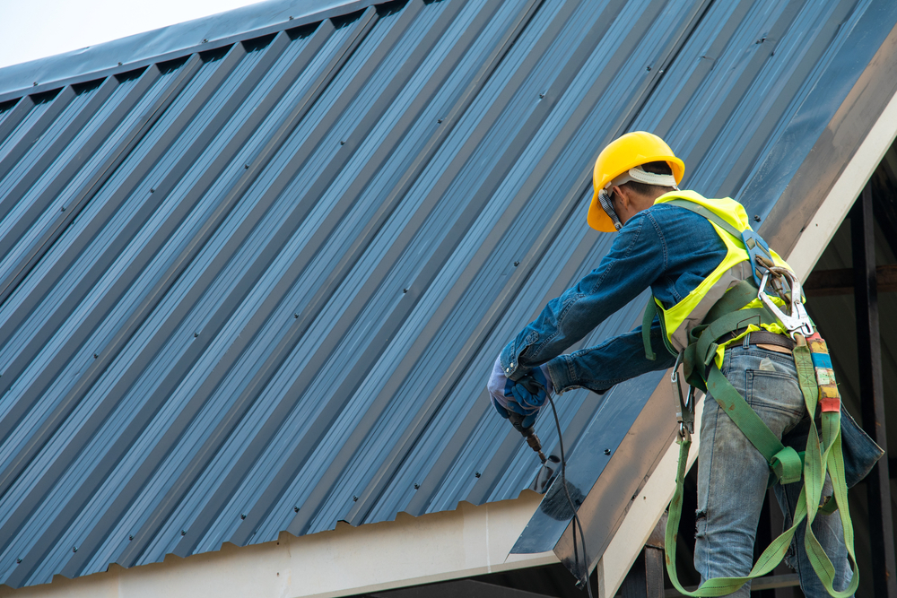 man installing metal roof