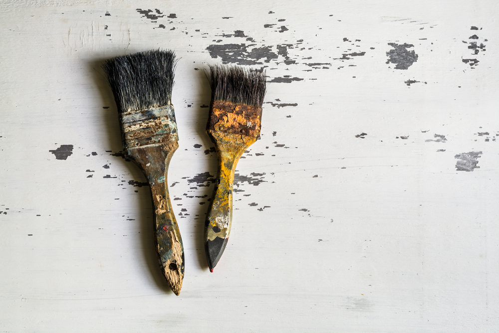 two dirty brushes with dried-on paint