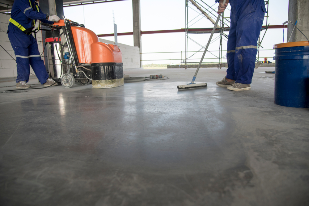 two professional polishing and cleaning a concrete floor