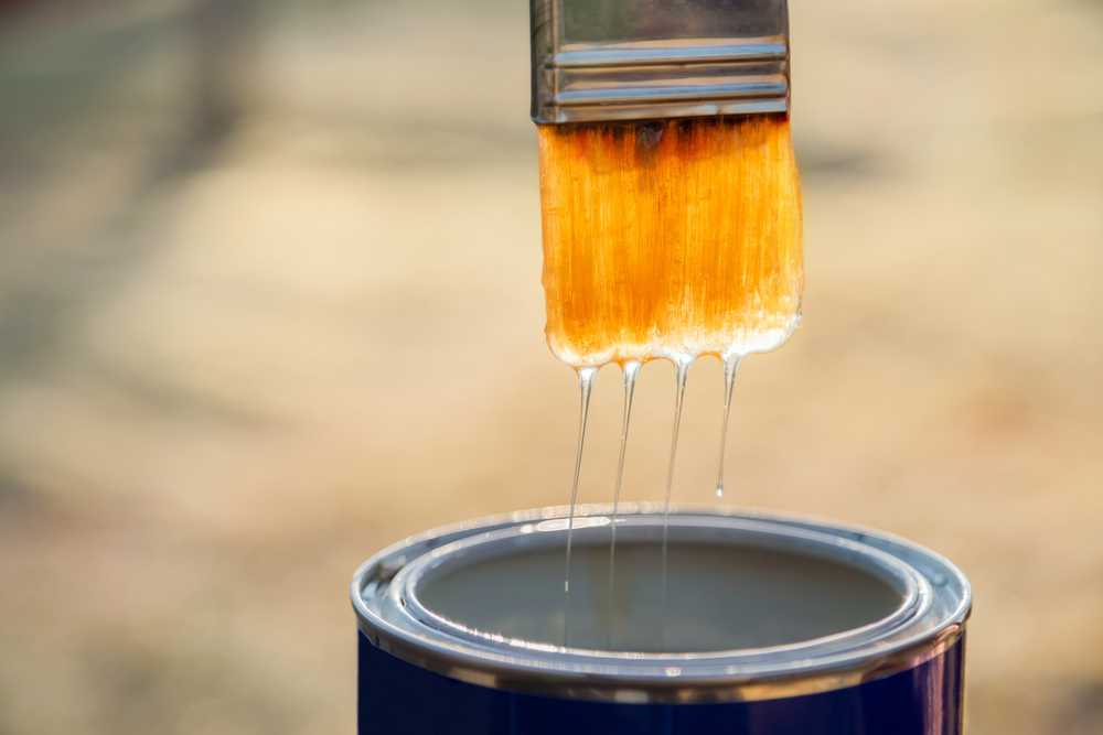 A person applying a layer of varnish