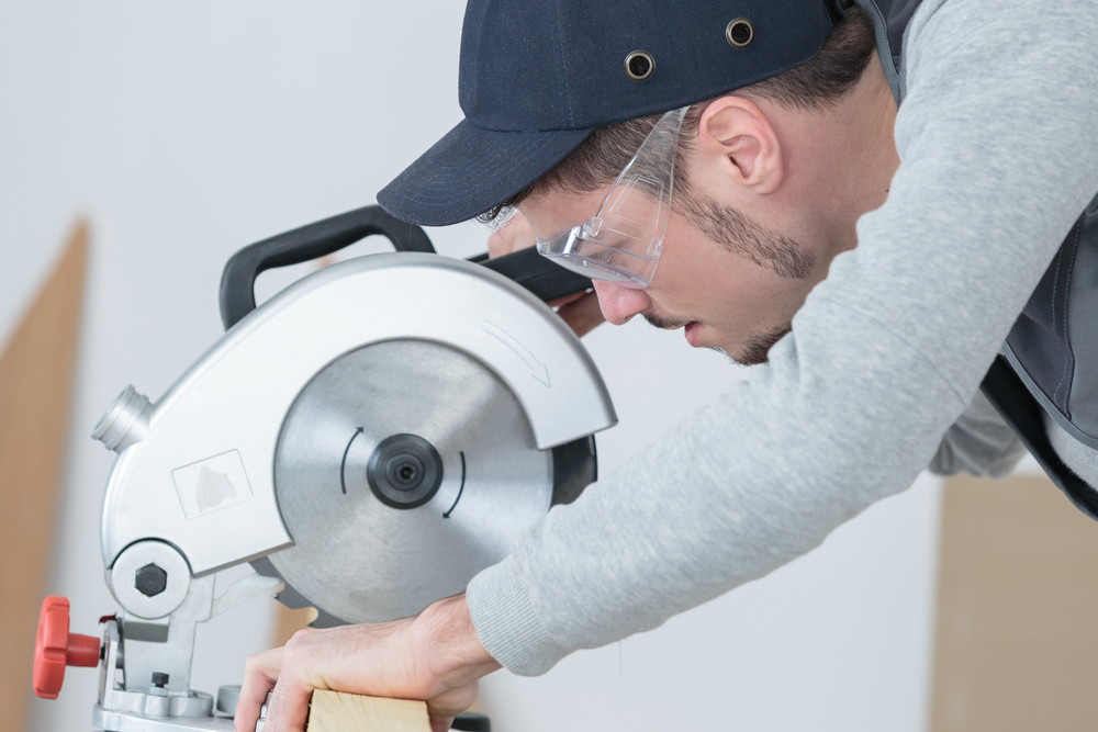 a man using a circular saw to cut