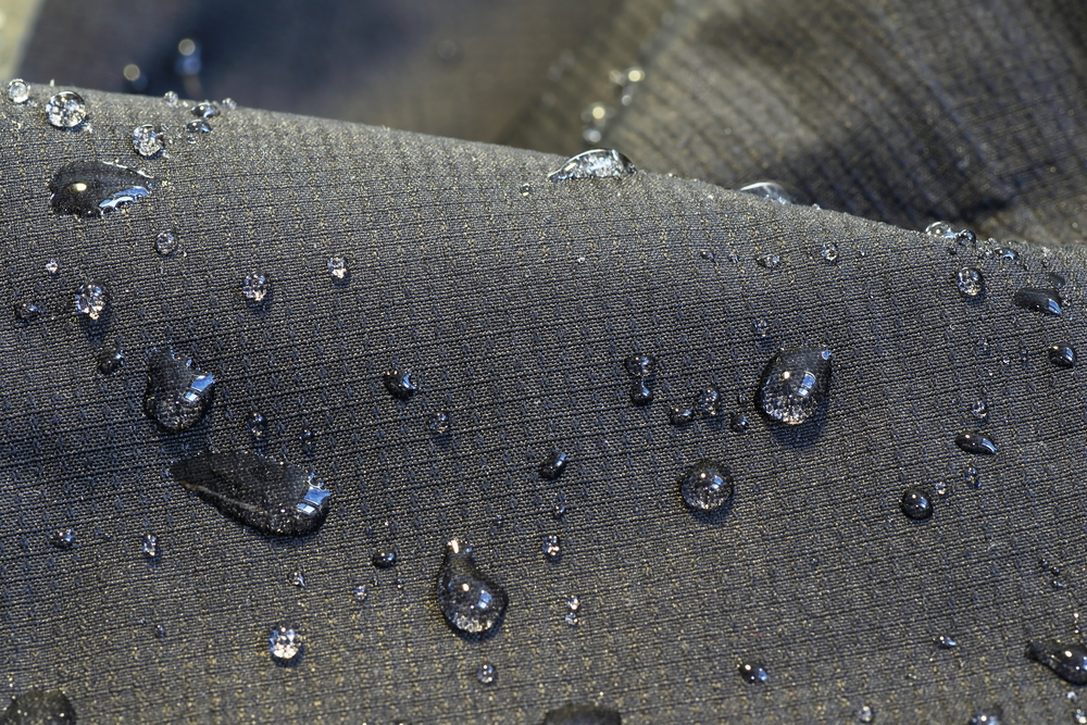 Close Up Of A Dark Gray Waterproof Fabric With Water Droplets On Top 