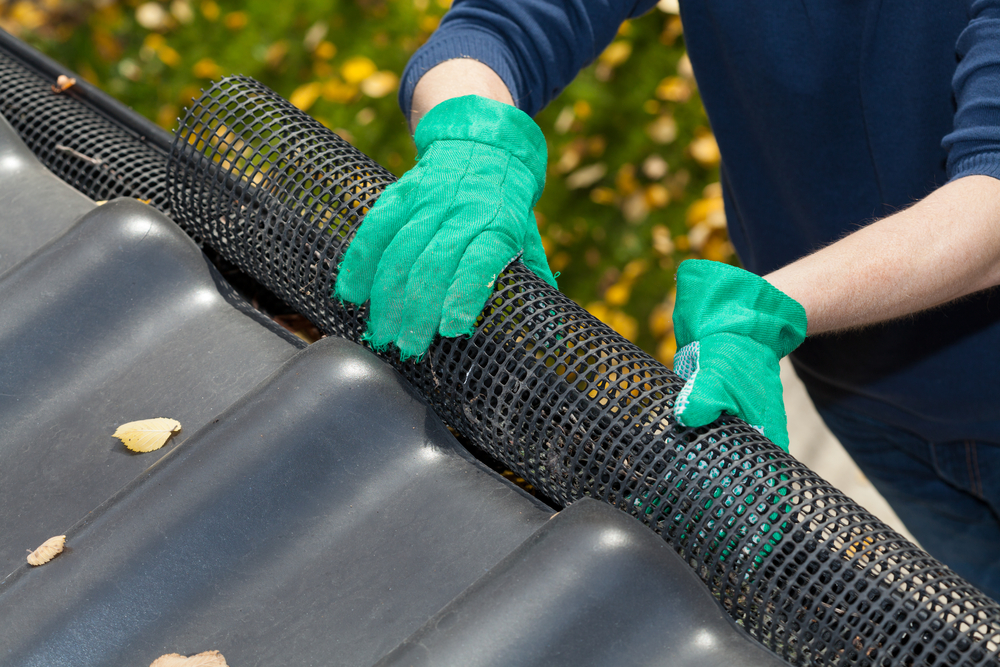 contractor installing leaf guard on rain gutter