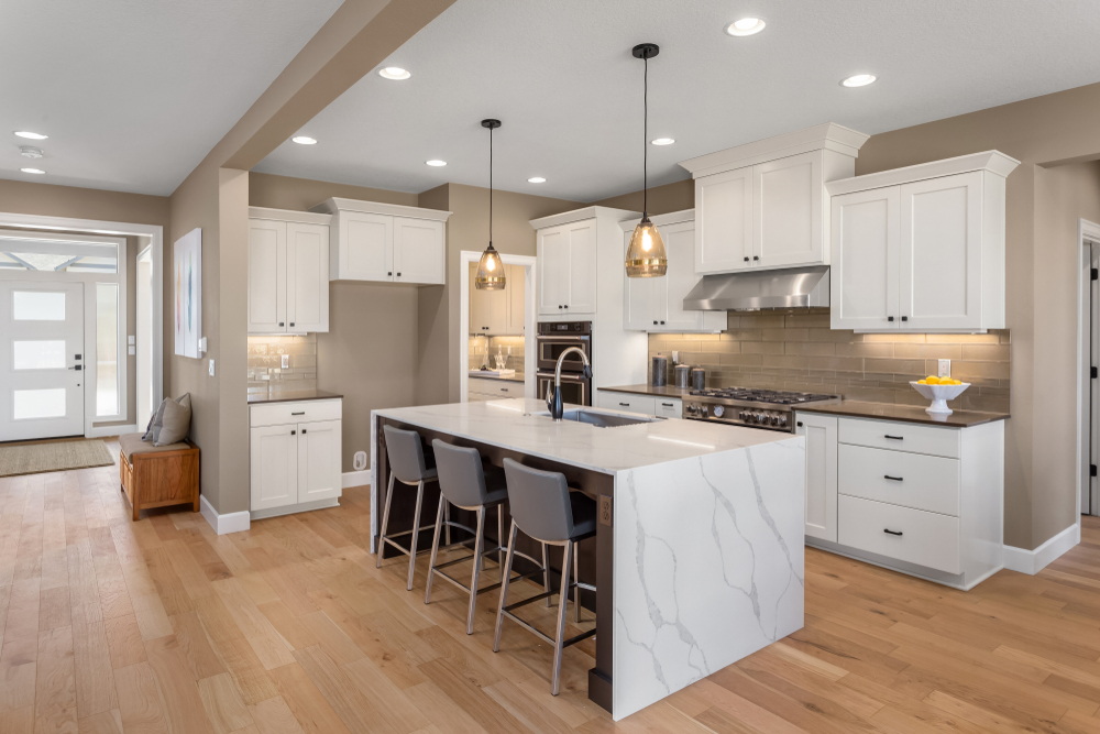 luxurious kitchen with marble waterfall island and hardwood floors