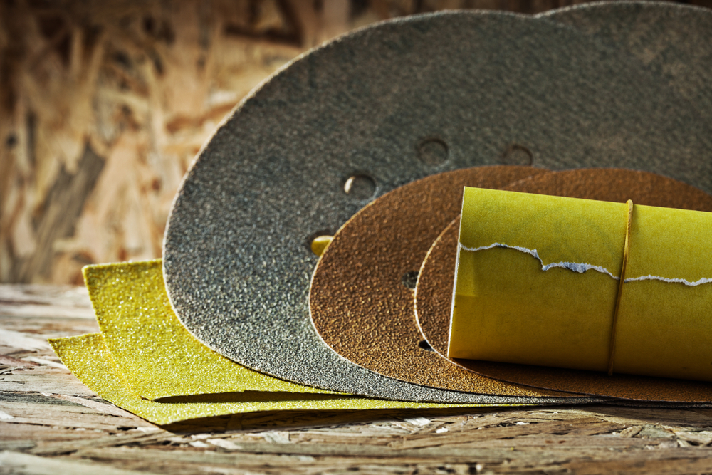 rolled sheets of sandpaper on plywood background