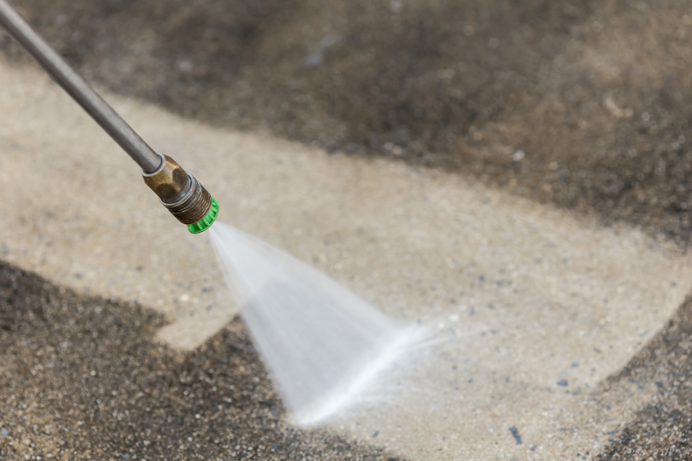using a power washer to clean a concrete floor