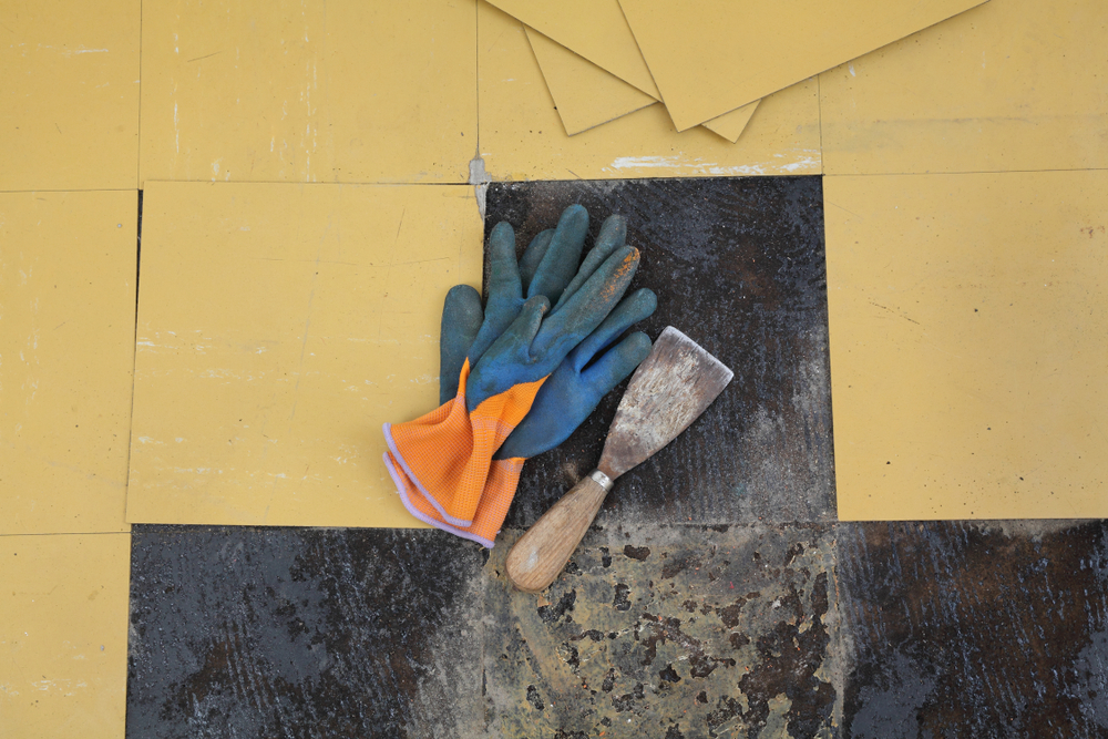 Tools on partially removed vinyl flooring