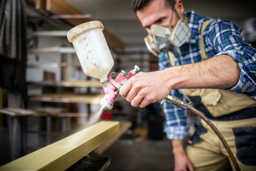 man holding compressor to paint